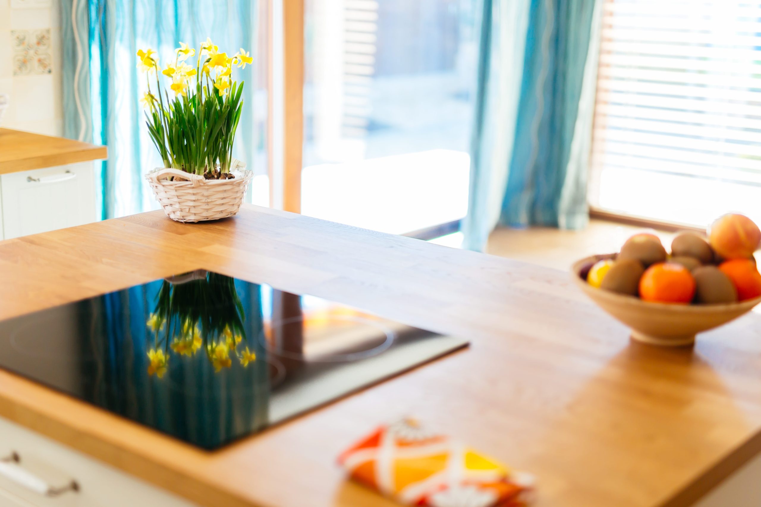 Flowers and a bowl of fruit sitting on a hardwood-topped kitchen island