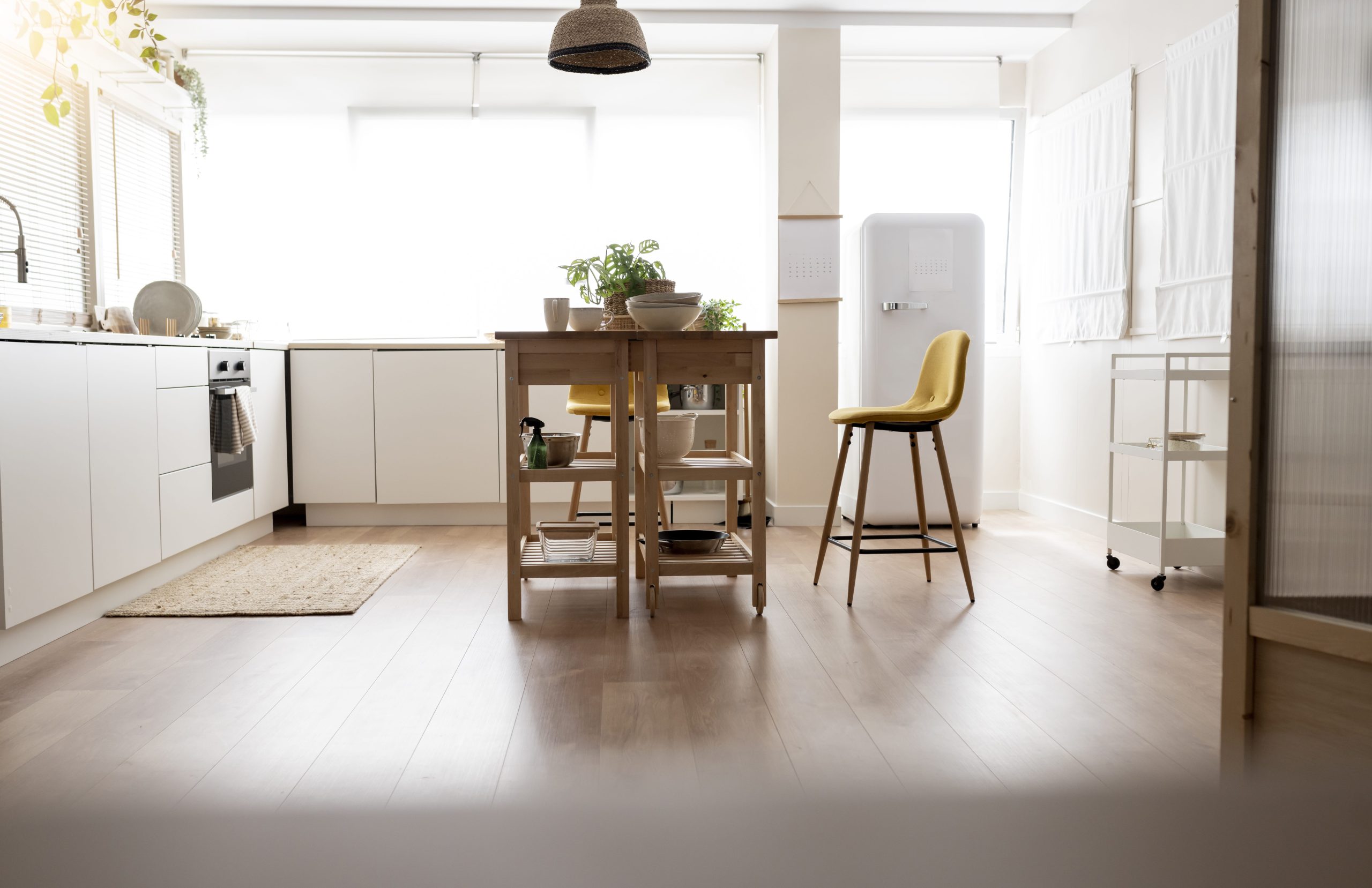 A kitchen filled with natural light, showcasing the timber laminate flooring.